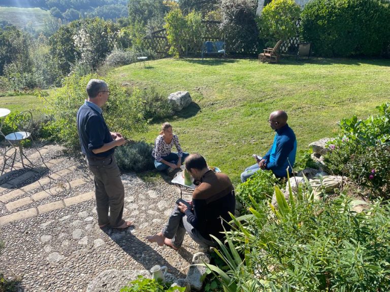 Groupe de participants échangeant dans un cadre naturel, représentant le travail sur soi pour être et agir en leader