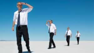 Homme en chemise blanche dans le désert cherchant l'horizon – métaphore visuelle de la quête de sens et de la transformation intérieure.
