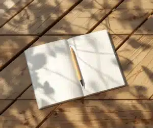 Carnet vierge et crayon posés sur une table en bois, symbole du temps calme nécessaire pour écouter son intuition